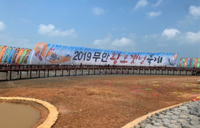 갯벌이 위의 다리에 현수막(2019 무안 황토갯벌축제)이 걸려있는 모습